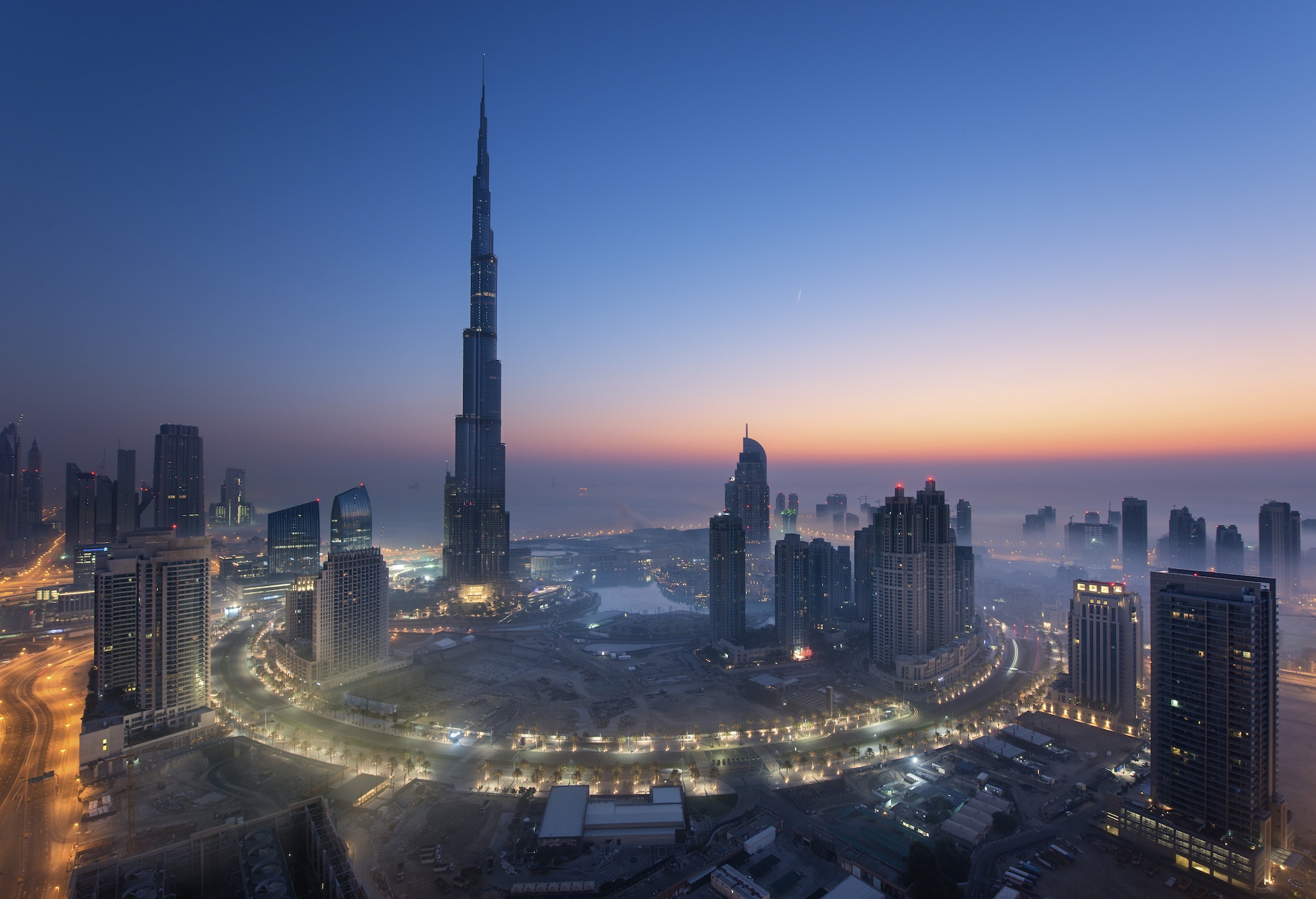 Cityscape of Dubai, United Arab Emirates at dusk, with the Burj Khalifa skyscraper and illuminated